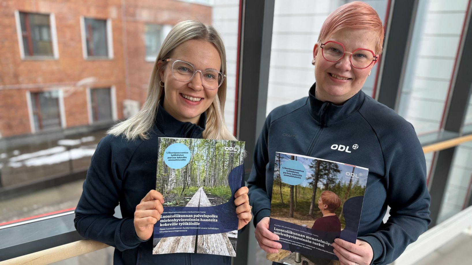 Mieliluontoon-hankkeen työntekijät pitelemässä oppaita